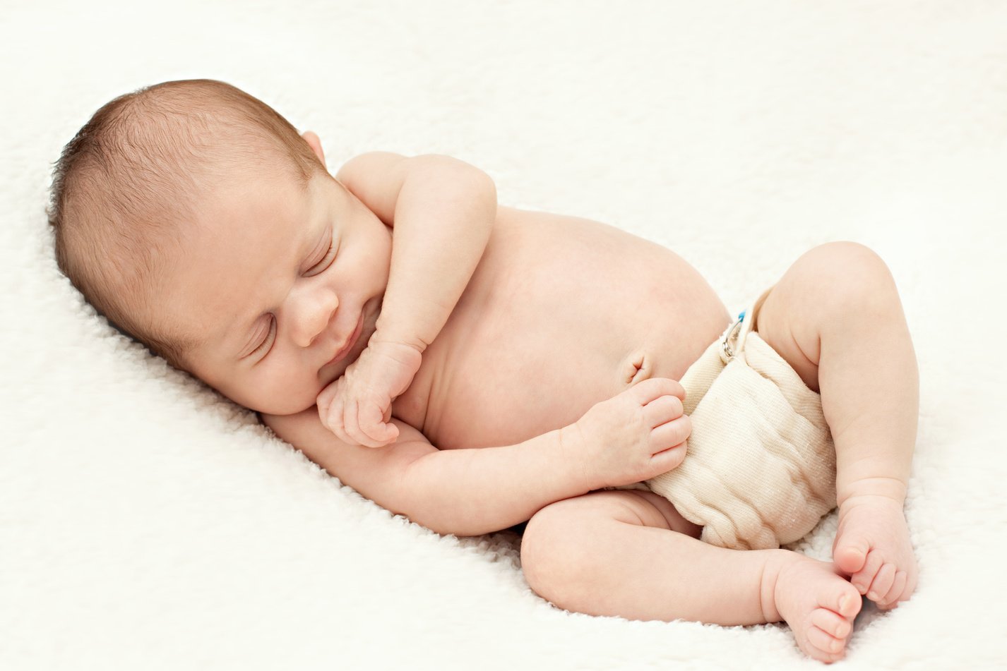 Sleeping newborn baby in cloth diaper